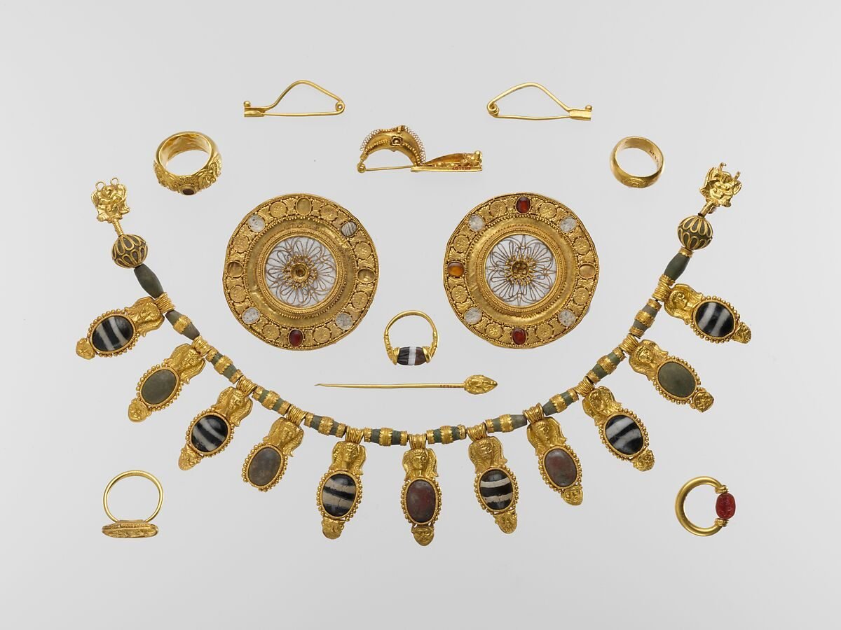 Etruscan gold jewelry set with necklace, disk ornaments, rings, fibulae, and pin